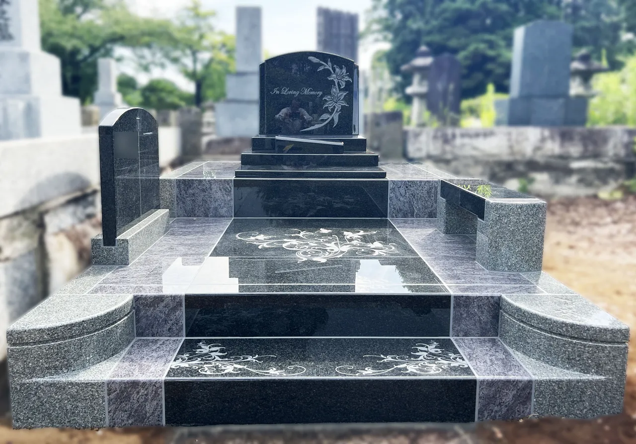 花の彫刻をあしらった黒とグレーの洋型墓石の施工例